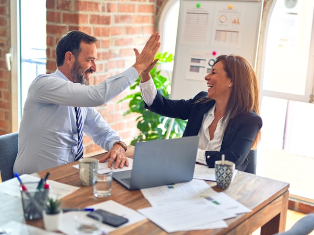 Two colleagues celebrating a successful hire