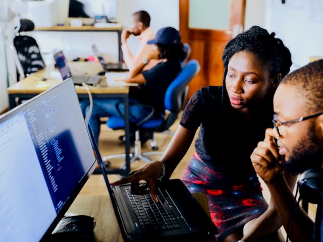 Colleagues reviewing work together on a screen